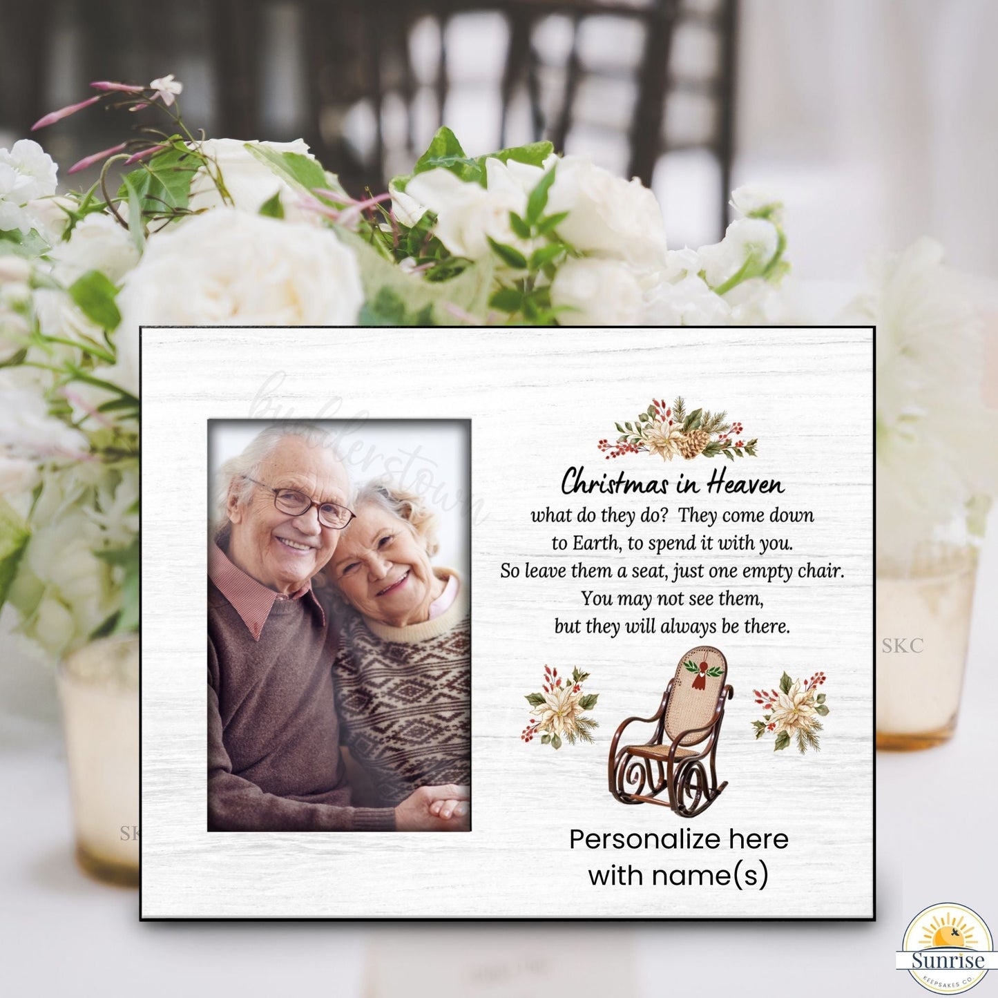 Memorial plaque with photo of an elderly couple and text about Christmas in Heaven, surrounded by flowers and a glass.