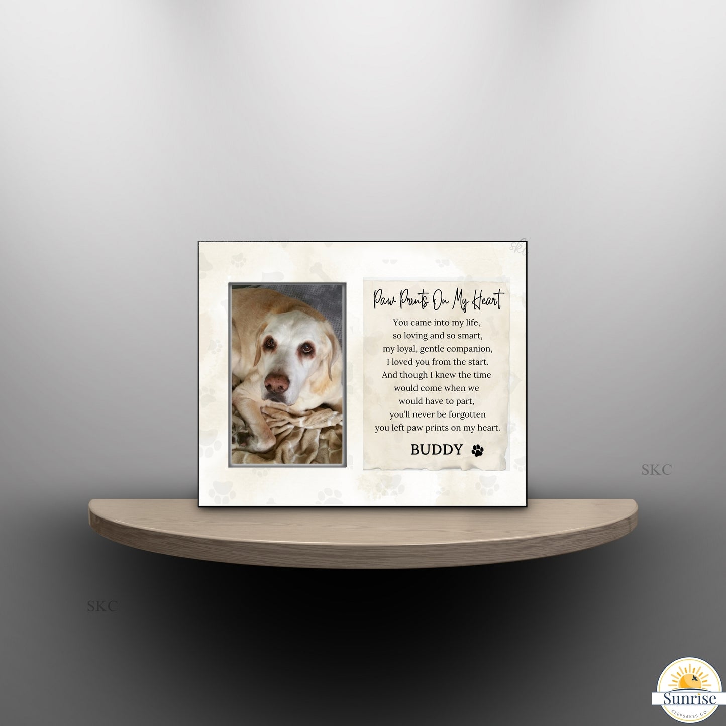 Framed picture of a dog and cat with a personalized message on a shelf against a gray background