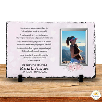 Personalized memorial slate plaque on black display stands, featuring a photo of a woman by a beach, Spanish remembrance text, and the names Maria L. Sanchez with dates, shown on a wooden surface.