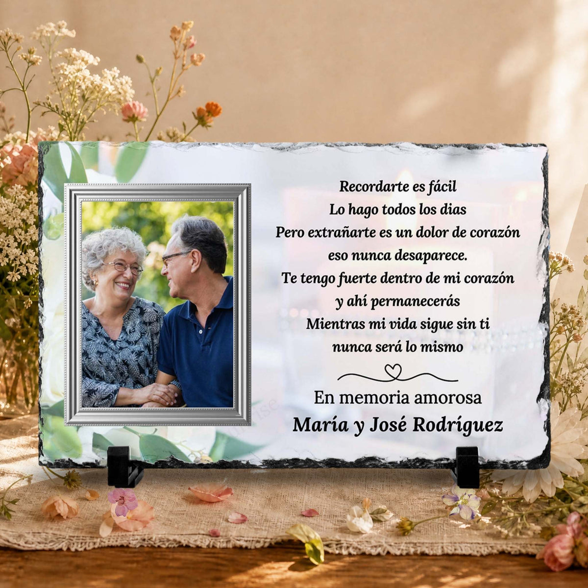 Personalized memorial slate plaque with a photo of a couple and Spanish remembrance text, displayed on a burlap surface with dried flowers and a warm neutral background.