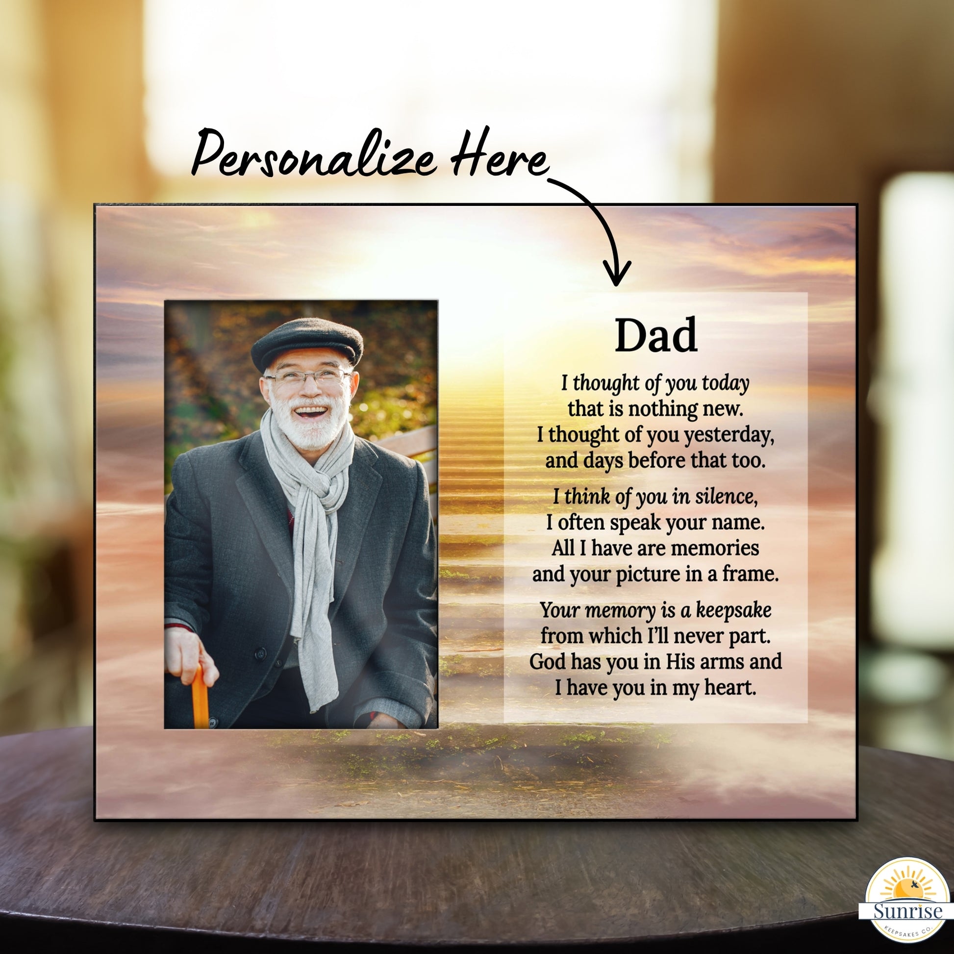 A personalized memorial plaque or print shown on a tabletop with a blurred indoor background. The design includes a photo of an older man, a censored area, and a memorial message headed 'Dad' with placeholder text.